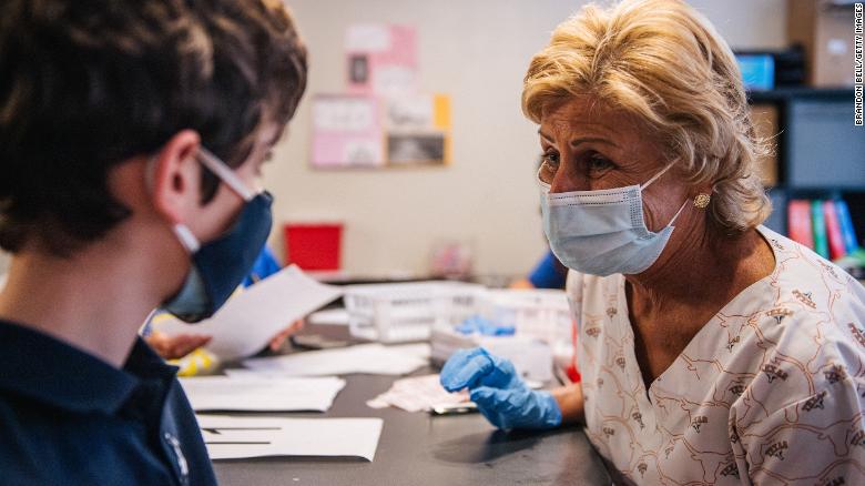 Marcie Weissman (right) comforts a child ahead of his shot in Houston, May 13. Three in 4 parents say their pediatrician will influence their decision about getting kids vaccinated against Covid-19.