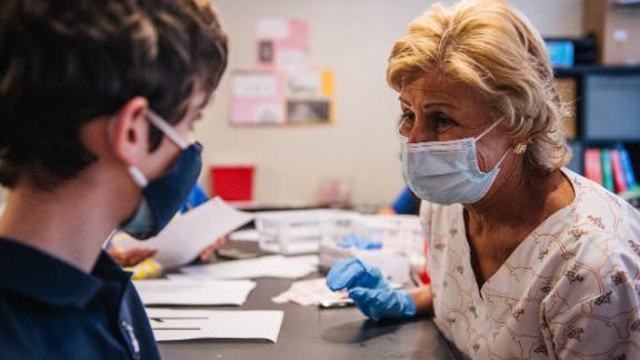 Marcie Weissman (right) comforts a child ahead of his shot in Houston, May 13. Three in 4 parents say their pediatrician will influence their decision about getting kids vaccinated against Covid-19.