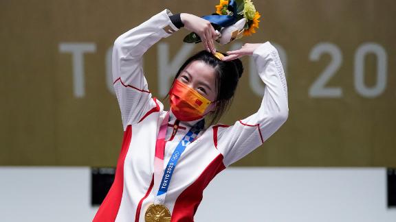 China's Yang Qian, the first gold-medal winner of these Olympics, celebrates on July 24. She finished first in the 10-meter air rifle.