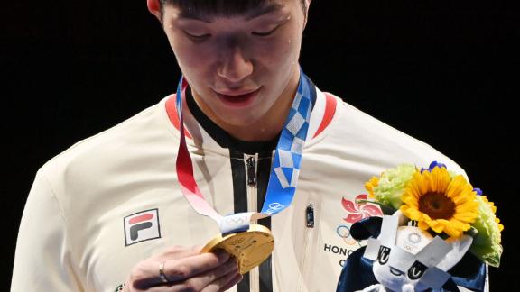 Hong Kong fencer Edgar Cheung looks at his gold medal after beating Italy's Daniele Garozzo in the men's foil final on July 26. It was <a href=