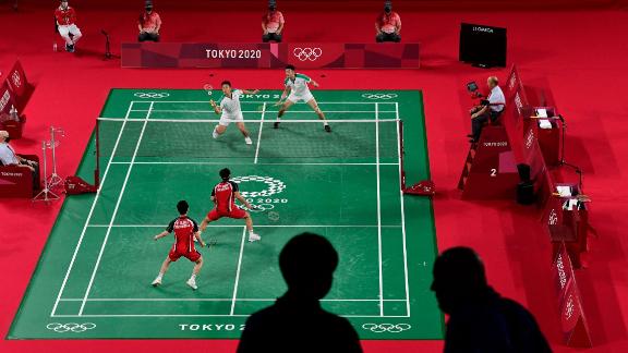 Members of the media are pictured in the foreground as Indonesia's Marcus Fernaldi Gideon, bottom left, and Kevin Sanjaya Sukamuljo play a badminton match against Taiwan's Lee Yang, top left, and Wang Chi-lin on July 27.