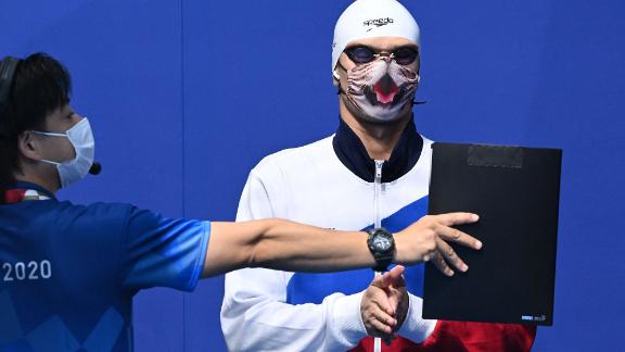 Russian swimmer Evgeny Rylov wears a cat-themed mask as he waits to receive his gold medal on July 27. <a href=