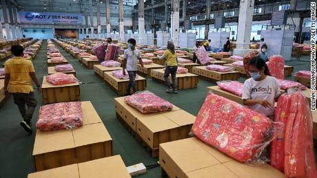 Workers prepare mattresses and blankets for some 1,800 cardboard beds at a Covid-19 field hospital inside a warehouse at the Don Mueang International Airport in Bangkok on July 27.