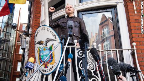 Julian Assange raises his fist as he steps out to speak to the media from the balcony of the Embassy Of Ecuador on May 19, 2017 in London.