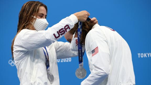 US swimmer Katie McLaughlin places a silver medal around the neck of teammate Katie Ledecky after the 4x200-meter freestyle relay on July 29. The International Olympic Committee created a contactless medal ceremony, asking athletes to put their medals on themselves. Some athletes have been <a href=