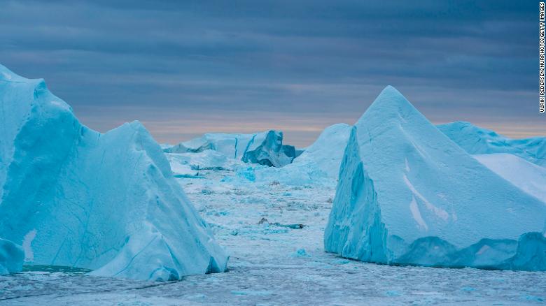 Warmer coastal water melts the Greenland ice sheet around the edges, breaking off massive icebergs that contribute to sea level rise.