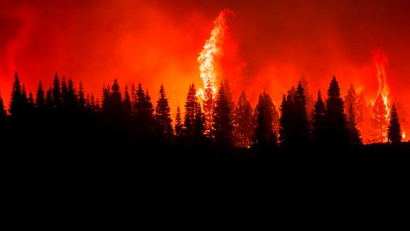 Flames from the Dixie Fire crest a hill in Lassen National Forest on Monday.