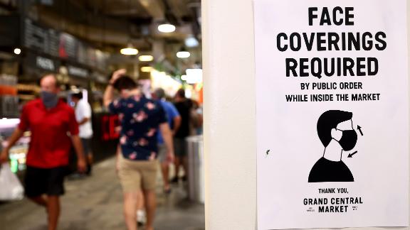 LOS ANGELES, CALIFORNIA - JULY 19: A sign is posted about required face coverings in Grand Central Market on July 19, 2021 in Los Angeles, California. A new mask mandate went into effect just before midnight on July 17th in Los Angeles County requiring all people, regardless of vaccination status, to wear a face covering in public indoor spaces amid a troubling rise in COVID-19 cases. (Photo by Mario Tama/Getty Images)