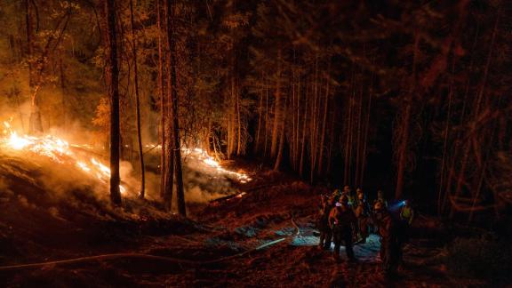 Members of the Fulton Hotshots work through the night at the Dixie Fire near Quincy, Calif., Monday.