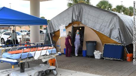 Enfermeras en una carpa de tratamiento fuera del departamento de emergencias del Centro Médico Regional Holmes en Melbourne, Florida, que sirve como un área de desbordamiento para personas con infecciones por Covid-19.