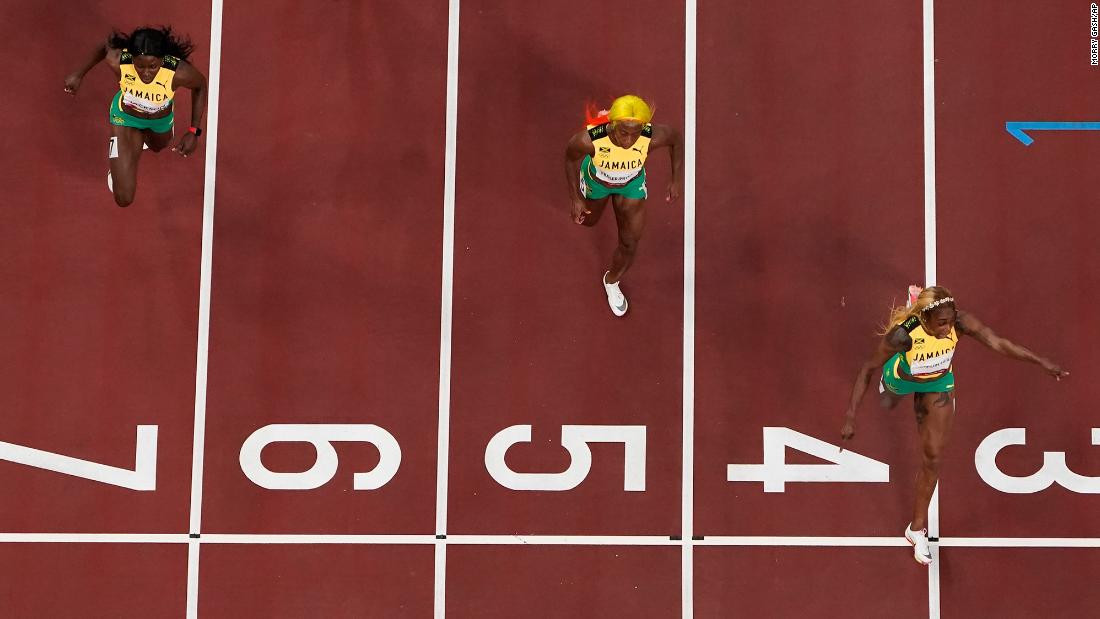 Thompson-Herah crosses the finish line first in the 100 meters. Fraser-Pryce, center, won this event in 2008 and 2012.