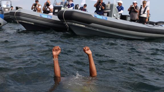 Dutch sailor Kiran Badloe jumps into the water to celebrate after winning gold in the men's RS:X category on August 1.