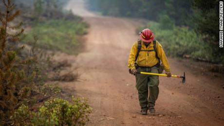 A firefighter from New Mexico walks up a dirt road after working to help contain the Bootleg Fire near Silver Lake, Oregon, on July 29, 2021. 