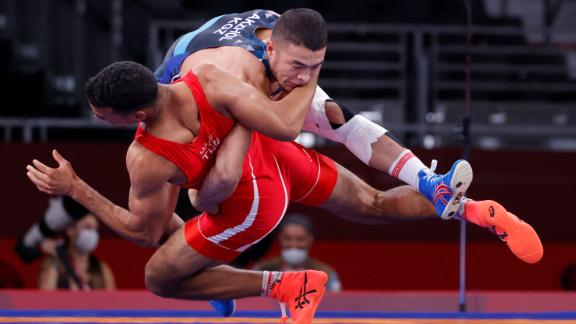 Kyrgyzstan's Akzhol Makhmudov, top, competes against Tunisia's Lamjed Maafi in Greco-Roman wrestling on August 2. Makhmudov went on to win a silver medal.