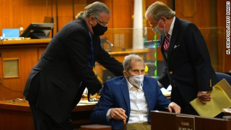 Defense attorneys David Z. Chesnoff, left, and Dick DeGuerin, right, adjust Robert Durst&#39;s wheelchair during opening statements in his murder trial on May 18, 2021.