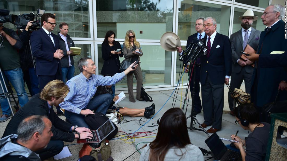 Attorney Dick DeGuerin waves his hat to end a media briefing outside the courthouse following a preliminary hearing for Durst in Los Angeles on December 21, 2016. 