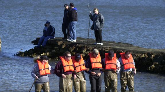 Private detectives comb a portion of Galveston Bay in search of Morris Black's remains in February 2002.