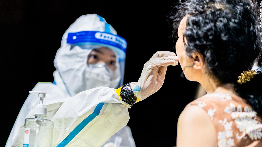 A medical worker collects a throat swab sample from a citizen for nucleic acid testing during a citywide Covid-19 testing campaign on August 3, 2021, in Wuhan, Hubei province of China.