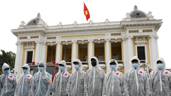 Soldiers from the High Command of Chemicals under Vietnam's Ministry of National Defence before spraying disinfectant throughout the streets of Hanoi on July 26.