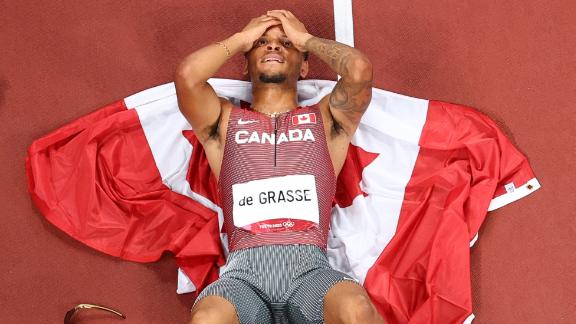 Canadian sprinter Andre De Grasse lies on the track after <a href=