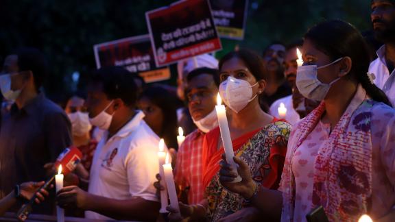Protesters march with lit candles and placards on August 4 in Delhi, India. 