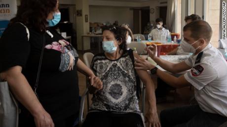 Eine israelische Frau erhält am Mittwoch in einem Seniorenzentrum in Jerusalem einen dritten Coronavirus-Impfstoff.