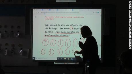 Gilbert teaches students how to solve a word problem during the past school year.