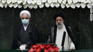 Raisi, right, takes his oath as president in Thursday&apos;s ceremony. 