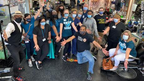 Mike Brown, kneeling in front, owner of The Shop Spa in Hyattsville, Maryland, hosted a vaccine clinic with local health professionals at his barbershop on May 17. More than 30 people were vaccinated that day.