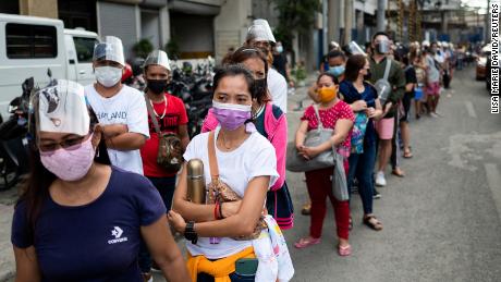 FILE PHOTO: Filipinos waiting to be vaccinated against the coronavirus disease (COVID-19) queue outside a mall, a day before stricter lockdown measures are implemented, in Manila, Philippines, August 5, 2021. REUTERS/Lisa Marie David/File Photo