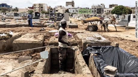 A man digs graves in Dakar, Senegal. After avoiding the worst of the virus, Senegalese cemetery workers and doctors are battling a deadly Covid-19 wave spurred by the Delta variant and low vaccination rates.