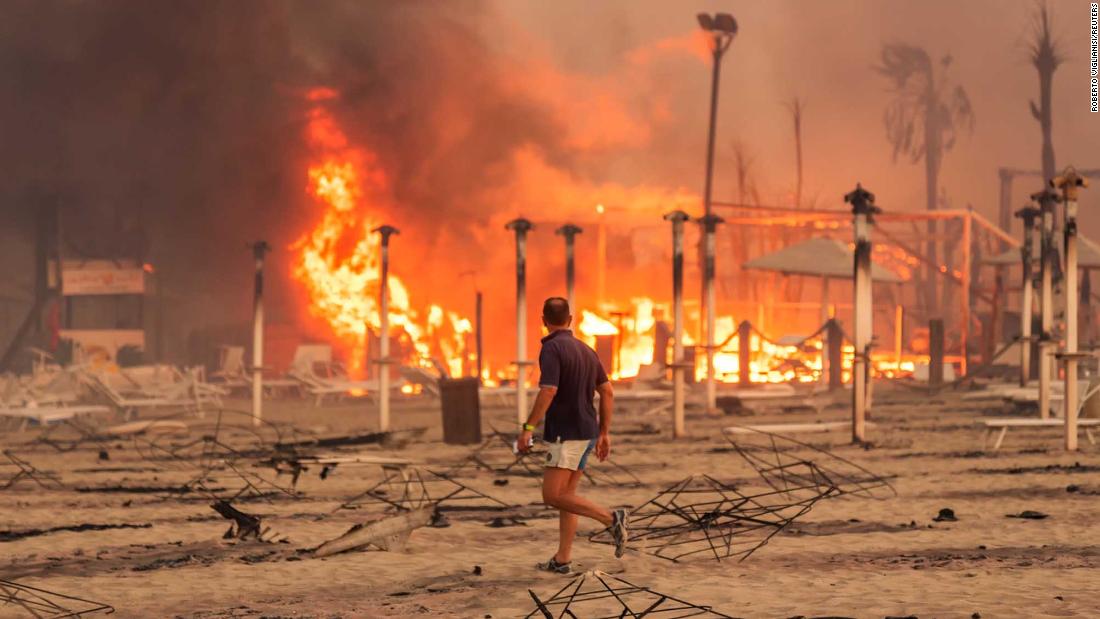 A man surveys a fire at Le Capannine beach in the Sicilian town of Catania, Italy, on July 30.