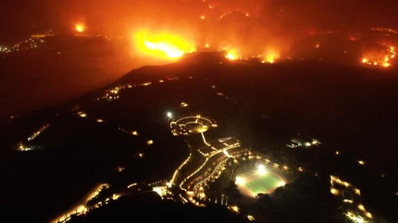 A wildfire approaches the Olympic Academy, foreground, in Olympia, Greece, on Wednesday, August 4.
