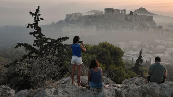 Onlookers view the smoke from the wildfires blanketing Athens' Acropolis on August 4.