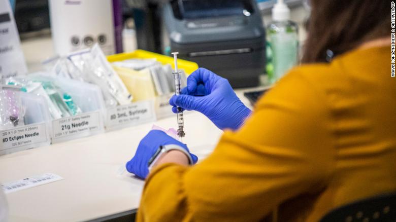 A health care worker prepares a Pfizer vaccine dose at a large-scale vaccination site at the University of North Carolina at Chapel Hill.