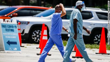 Health care workers leave following a shift at a drive-thru Covid-19 testing site at Tropical Park in Miami on Friday, August.