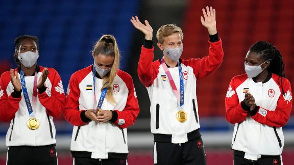 Canadian footballer Quinn waves during a medal ceremony in Yokohama, Japan. Quinn, who goes by just the one name, is <a href=