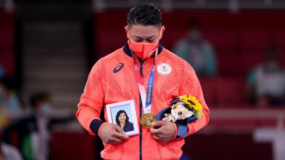Japan's Ryo Kiyuna holds a photo of his late mother after <a href=