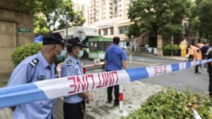 Police, security guards and volunteers help enforce a cordon around a neighborhood placed under lockdown, after a resident recently tested positive for Covid-19, in Shanghai, China, on Tuesday, Aug. 3, 2021. China reported 61 confirmed Covid-19 cases and 23 asymptomatic infections on Tuesday, as the outbreak that originated with a flight from Moscow continues to spread around the country. Photographer: Qilai Shen/Bloomberg via Getty Images