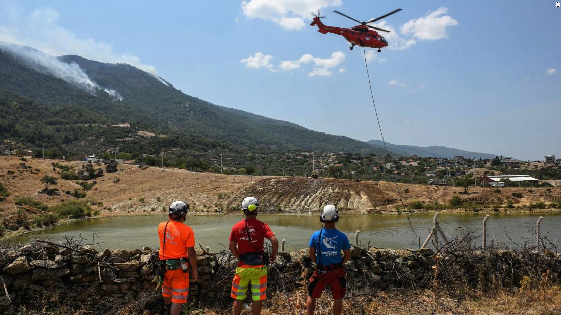 A firefighting helicopter takes water from a lake near Cine, Turkey.