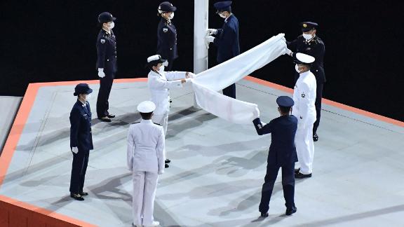 The Olympic flag is folded after being lowered during the closing ceremony.