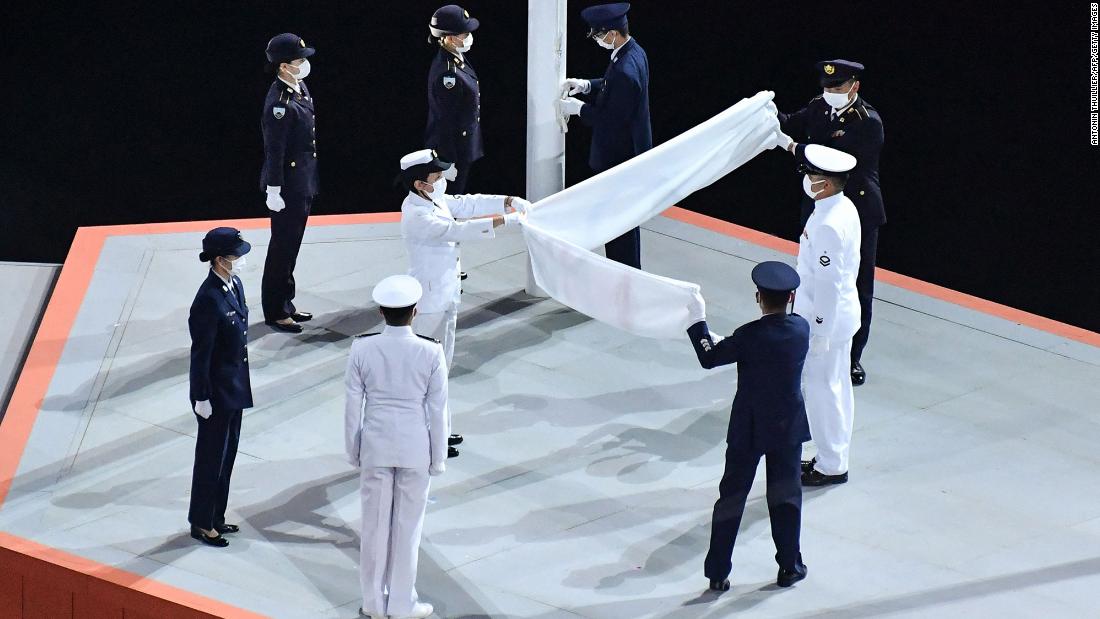 The Olympic flag is folded after being lowered during the closing ceremony.