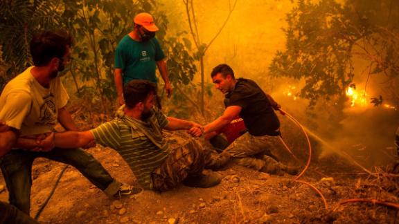 Residents battle a wildfire in the village of Gouves on the Greek island of Evia, on Sunday, August 8.