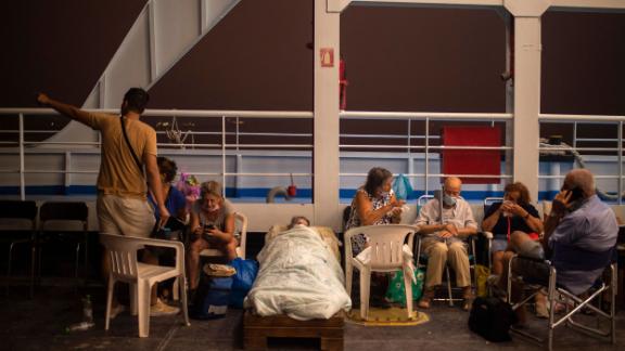 Elderly people are seen on chairs and makeshift bed onboard a ferry at the port of the village of Pefki, during a wildfire at Pefki village on Evia.