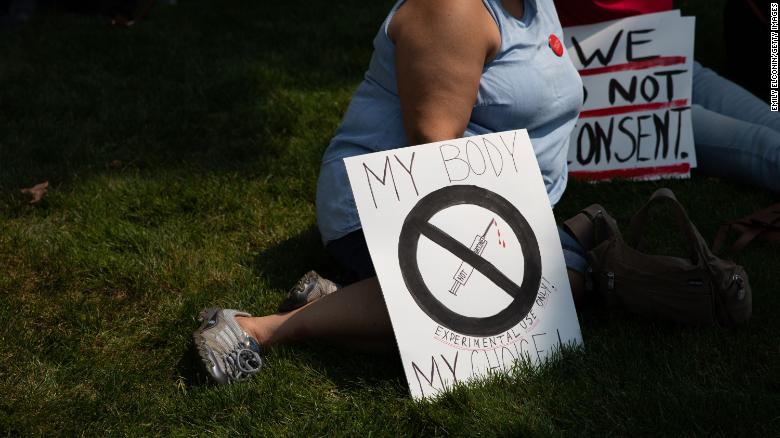 Demonstrators gather with signs to protest against mandated vaccines outside of the Michigan State Capitol on August 6, 2021 in Lansing, Michigan. 