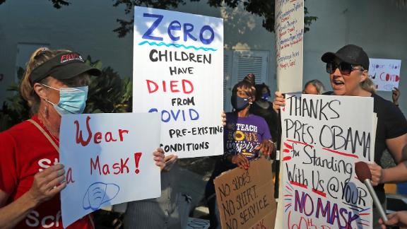 During a protest outside a Broward County School Board meeting on Tuesday, an anti-mask advocate, right, tries to convince a protester that students do not need to wear masks when they return to school.