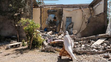 A woman walks in front of a damaged house which was shelled as federal-aligned forces entered the city, in Wukro, north of Mekele, on March 1, 2021. - Every phase of the four-month-old conflict in Tigray has brought suffering to Wukro, a fast-growing transport hub once best-known for its religious and archaeological sites. Ahead of federal forces&#39; arrival in late November 2020, heavy shelling levelled homes and businesses and sent plumes of dust and smoke rising above near-deserted streets. Since then the town has been heavily patrolled by soldiers, Eritreans at first, now mostly Ethiopians, whose abuses fuel a steady flow of civilian casualties and stoke anger with Nobel Peace Prize-winner Abiy. (Photo by EDUARDO SOTERAS / AFP) (Photo by EDUARDO SOTERAS/AFP via Getty Images)