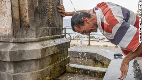 Un uomo trova poco sollievo dal caldo nell'isola italiana di Sicilia mercoledì. 