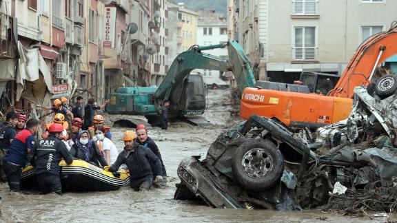 A rescue team evacuates residents in a boat in a residential area affected by heavy floods.