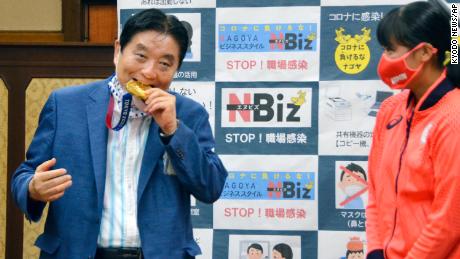 Nagoya Mayor Takashi Kawamura bites the Olympic gold medal of Miu Goto. 